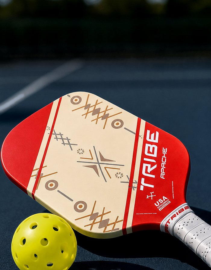 The TRIBE Apache resting on an outdoor court beside a pickleball
